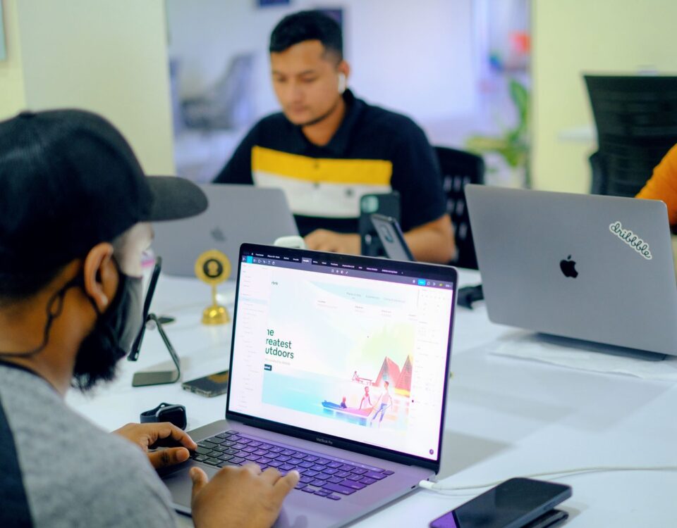 Business colleagues collaborating in an office setting with laptops and electronics.