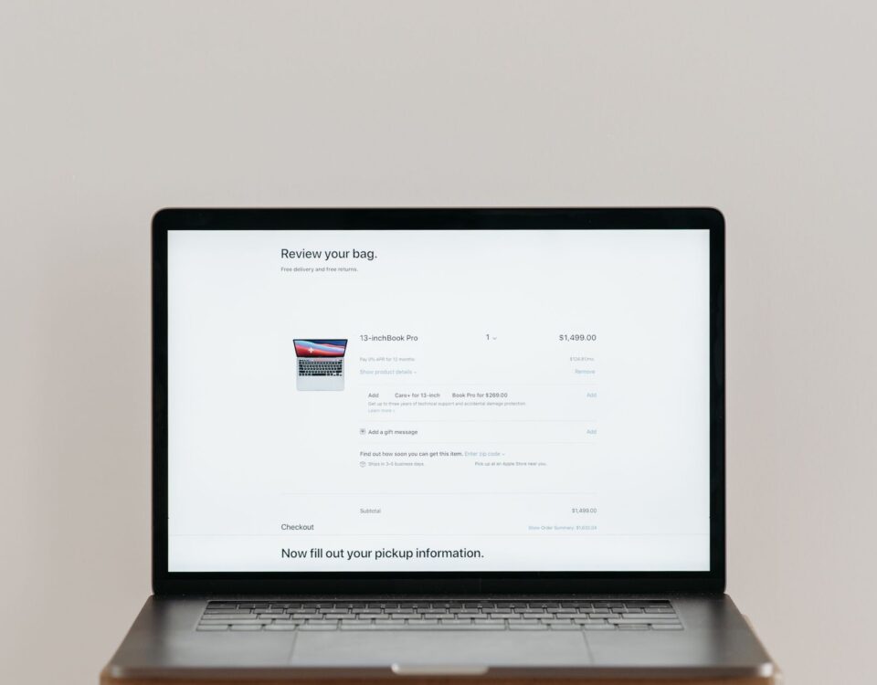 Minimalist laptop showing an online checkout screen on a white background, ideal for tech context.