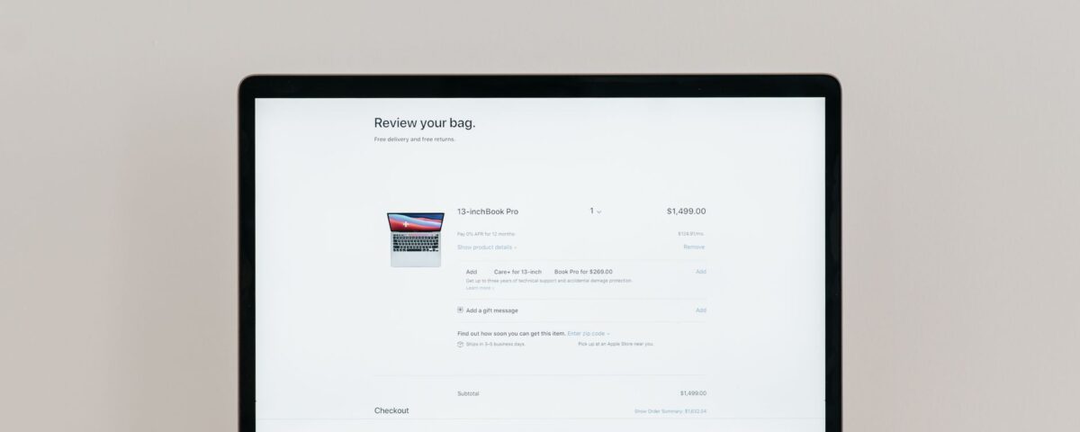 Minimalist laptop showing an online checkout screen on a white background, ideal for tech context.