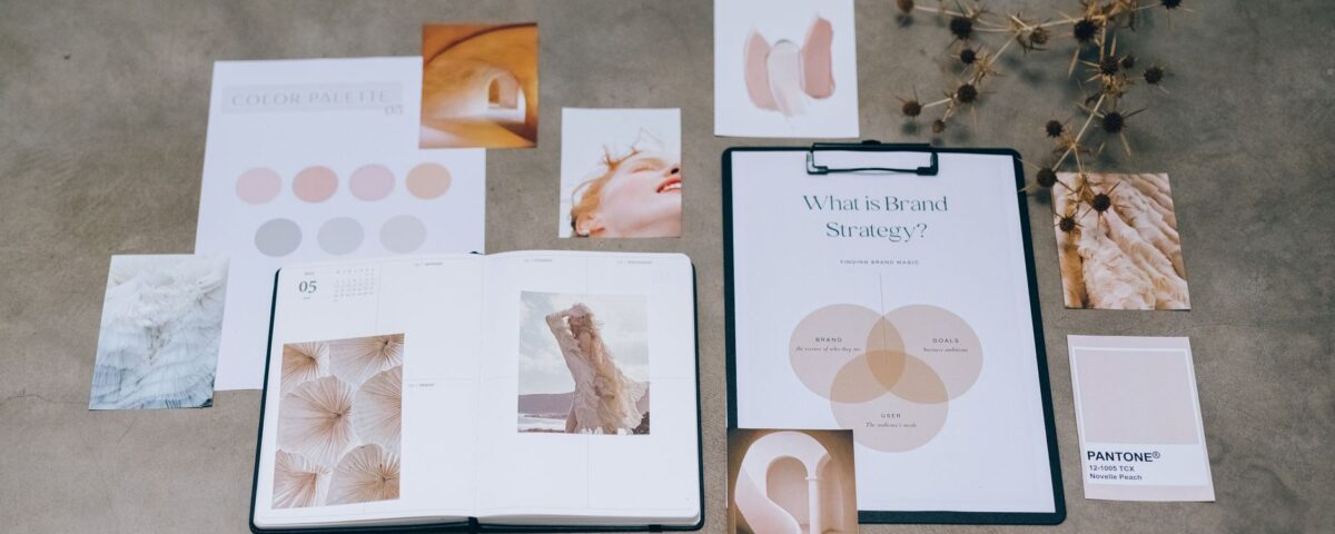 A flat lay of branding elements with color palettes and strategic planning documents on a concrete surface.