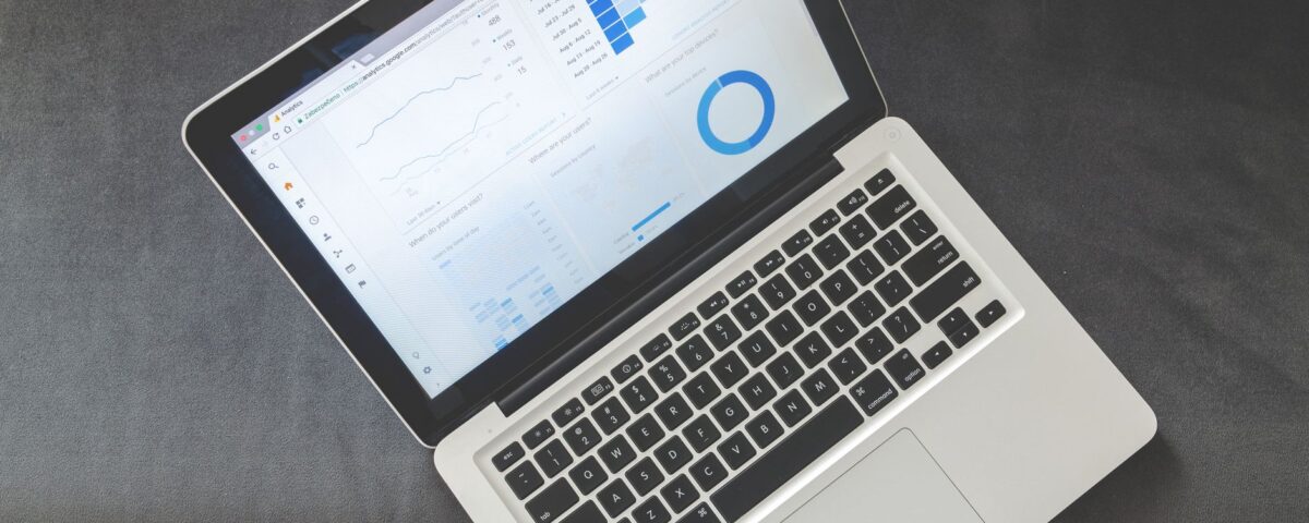 Overhead view of a laptop showing data visualizations and charts on its screen.