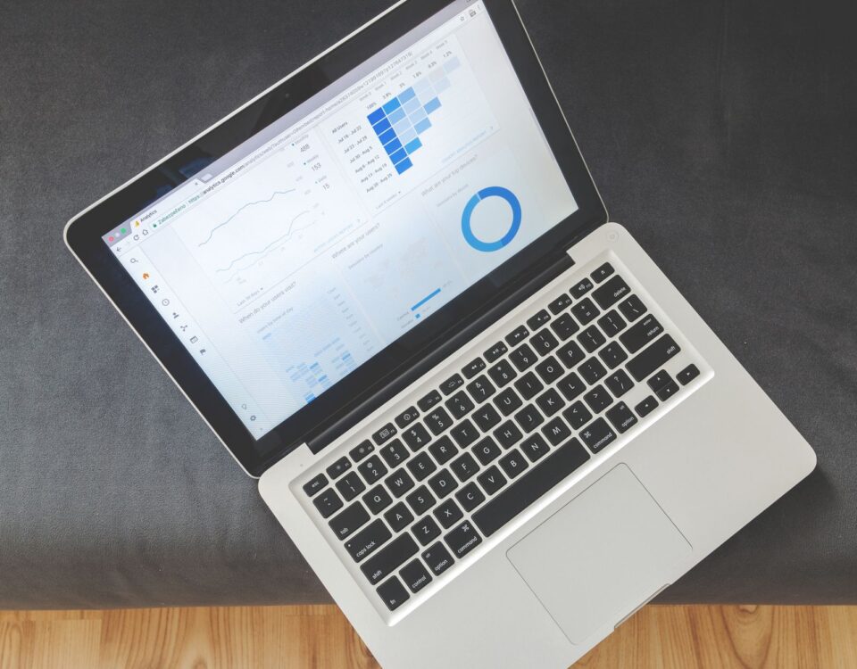 Overhead view of a laptop showing data visualizations and charts on its screen.